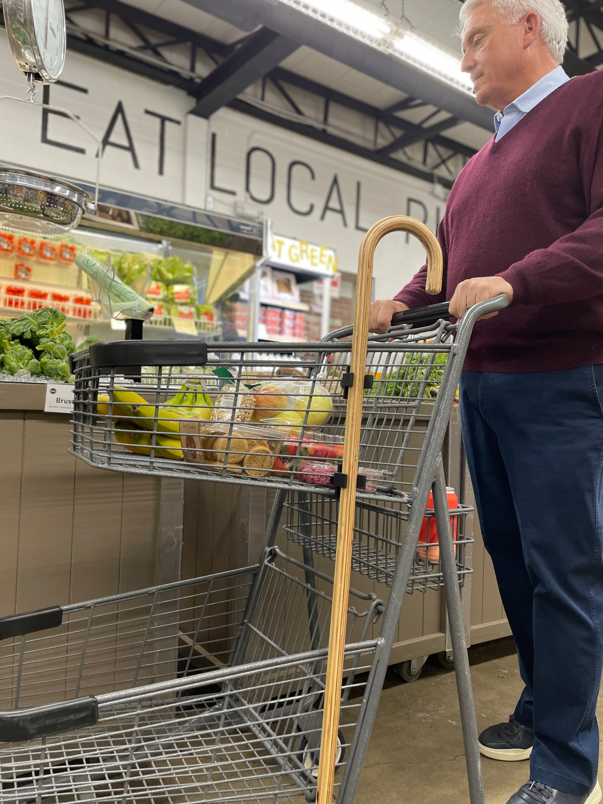 man grocery shopping with clip to cart