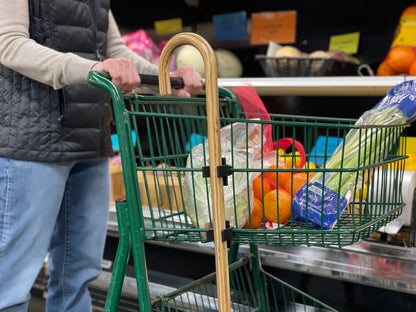 wooden cane clipped to a shopping cart