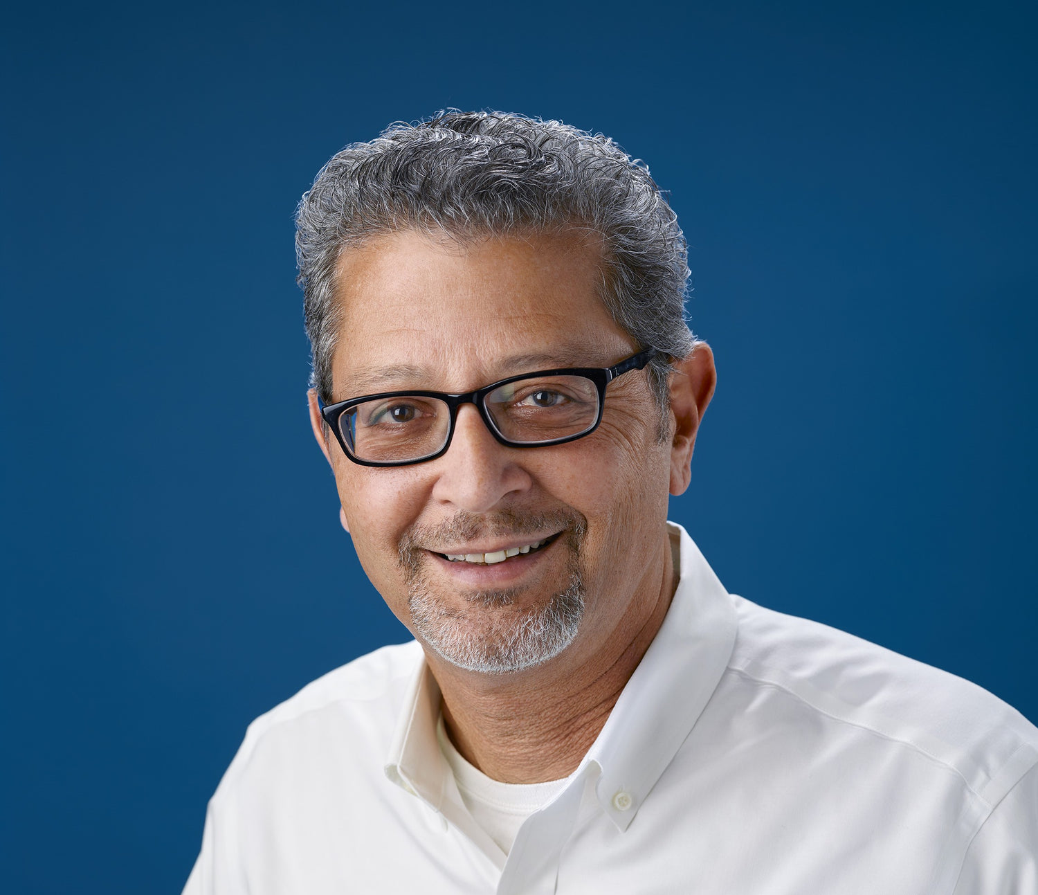 man glasses salt pepper smiling white shirt